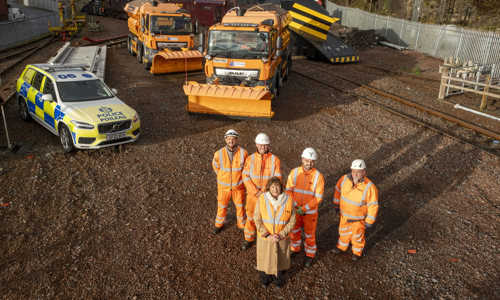 Transport Secretary Fiona Hyslop poses for a photo with winter service colleagues, in front of resilience vehicles at a rail depot.