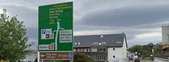 Green primary route direction sign on the northbound A87 at Kyle of Lochalsh, including direction to Skye Bridge, Portree and Uig (with Gaelic versions in yellow text)