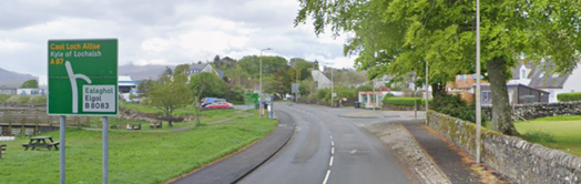 Green primary route direction sign on the southbound A87 at Broadford, including direction to Kyle of Lochalsh (with Gaelic version in yellow text)