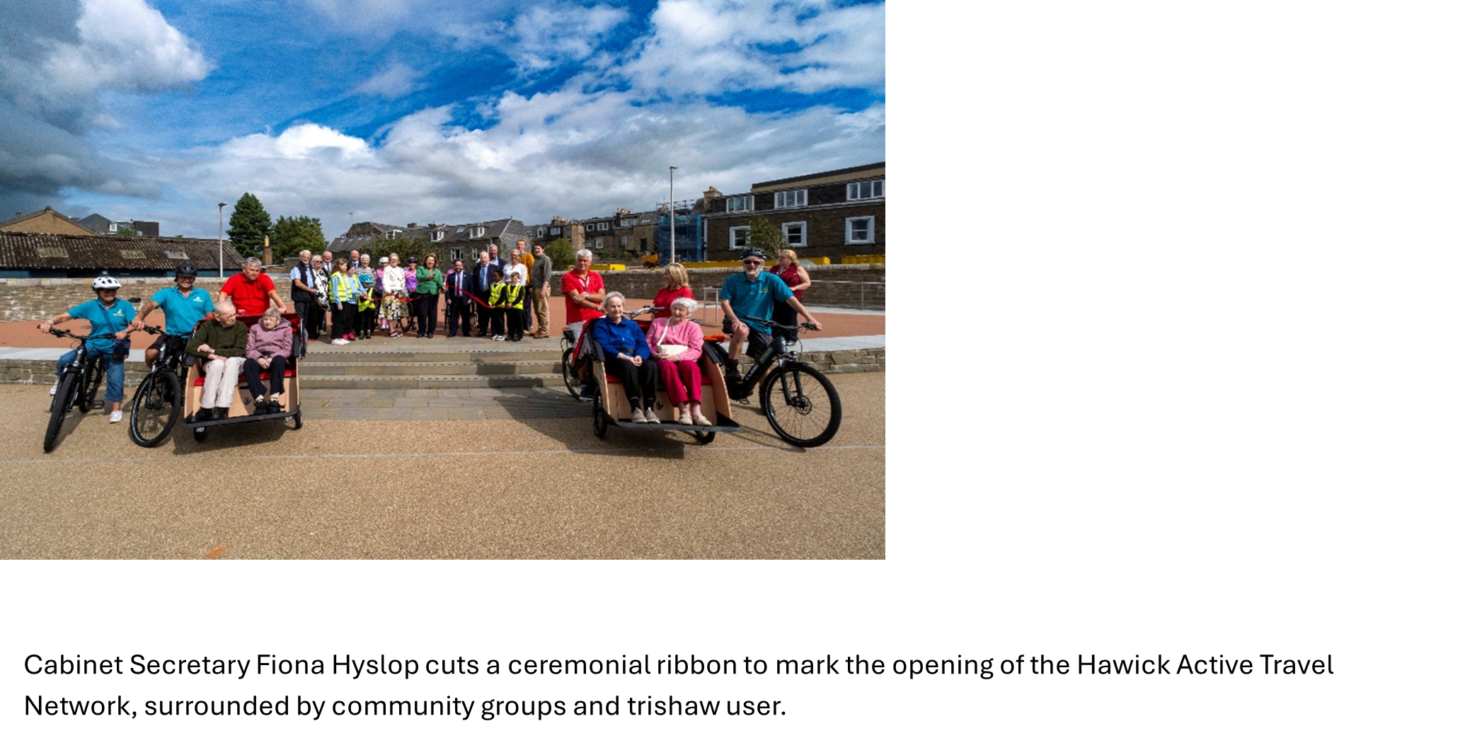 Cabinet Secretary Fiona Hyslop cuts a ceremonial ribbon to mark the opening of the Hawick Active Travel Network, surrounded by community groups and trishaw user.